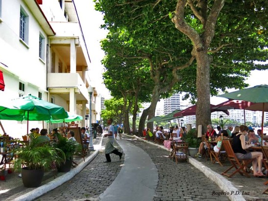 A alameda arborizada que conduz à fortificação, com as mesas sempre ocupadas da famosa Confeitaria Colombo, 