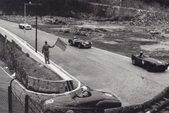 Na frente na Curva da Melco de 180º, o Triumph TR2 de Scott Leavitt (30) antes de ser ultrapassado pelo AC Ace de Ron Hardwick (7), e logo atrás o Aston Martins (19) de Chan Lye Choon que logo depois  ultrapassaria os dois para ganhar a corrida em 1958.
