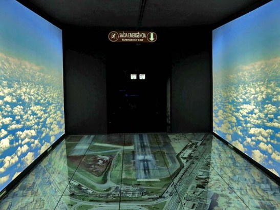 O primeiro acesso é por um corredor cultural, antes passando por um ambiente com nuvens dos dois lados e pisando sobre a fotografia do Aeroporto de Congonhas de São Paulo.