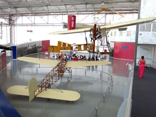 A rampa ao lado para acesso ao local de exposição. Vê-se ao fundo escolares recebendo informações de monitores diante de uma réplica do 14 Bis do pai de aviação Santos Dumont