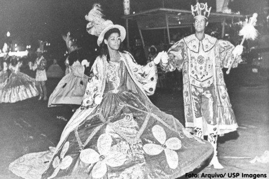 Escola de Samba Acadêmicos do Tatuapé desfilando em 1974-75 com o tema “Rei por um Dia”. A utilização de figuras reais nos desfiles era uma constante. Elas foram paulatinamente sendo substituídas pela figura do Mestre-Sala e da Porta-Bandeira. (USP Imagens)