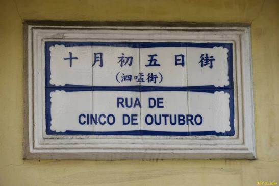 Os três caracteres chineses que estão escritos entre parênteses na placa toponímica lêem-se "si máng kai", isto é, Rua do Simão